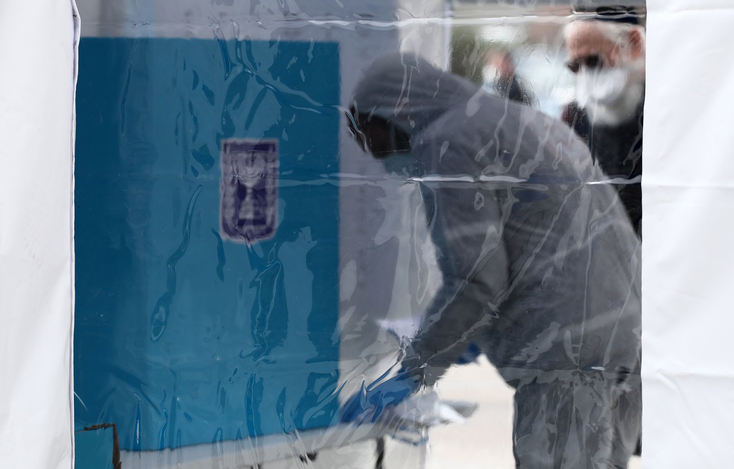 A member of Israel's Maguen David Adom (National Emergency Pre-Hospital Medical Organisation) works at a polling booth specially erected for the 5,600 voters under quarantine, many of whom visited countries where the coronavirus COVID-19 is prevalent, during parliamentary election on March 2, 2020 in Jerusalem. - Israelis were voting for a third time in 12 months today, with embattled Prime Minister Benjamin Netanyahu seeking to end the country's political crisis and save his career. (Photo by Gali TIBBON / AFP) (Photo by GALI TIBBON/AFP via Getty Images)